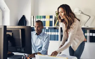 Woman and man looking at the computer monitor with interest